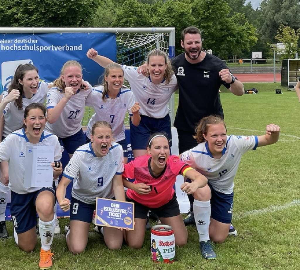 Nicolai König feiert mit der Frauenfußballmannschaft der Goethe-Uni den Erfolg.